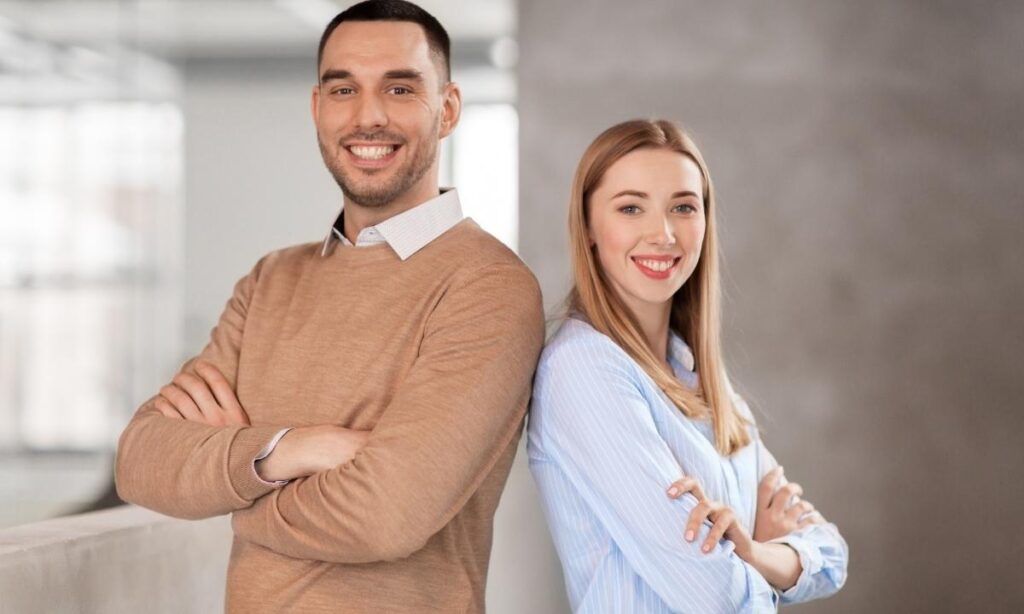 man and woman in business casual attire for a headshot posing back to back