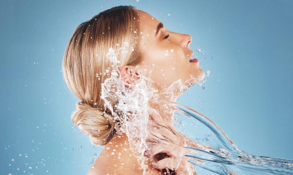 woman having water rush onto her face and neck representing well hydrated skin